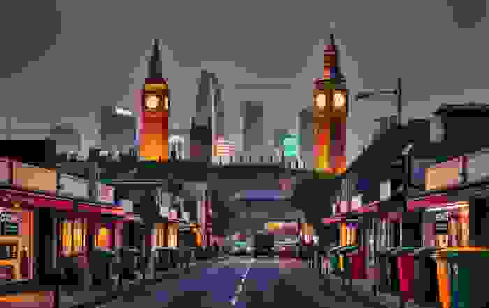A twilight view of Big Ben surrounded by modern skyscrapers, with a bustling street lined with shops and colorful trash bins.